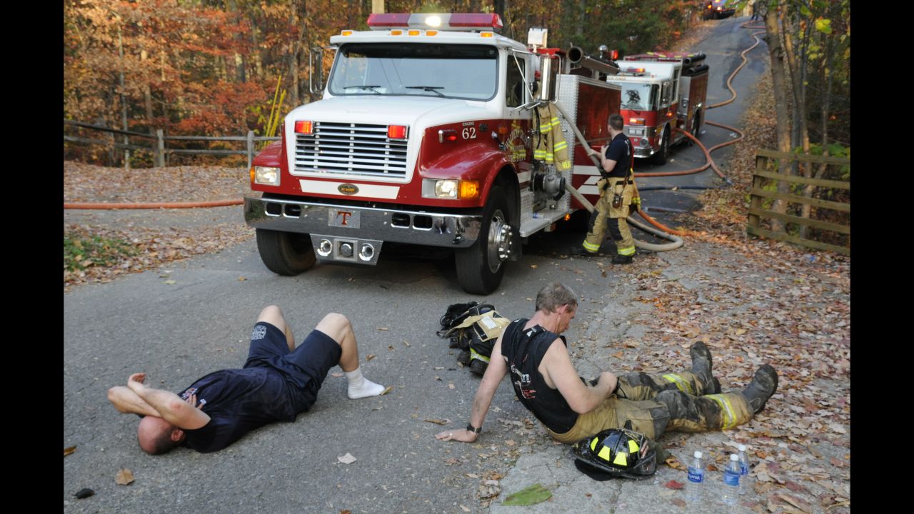 Exhausted firefighters take a break in Waldens Creek, Tennessee, on Monday, November 14.