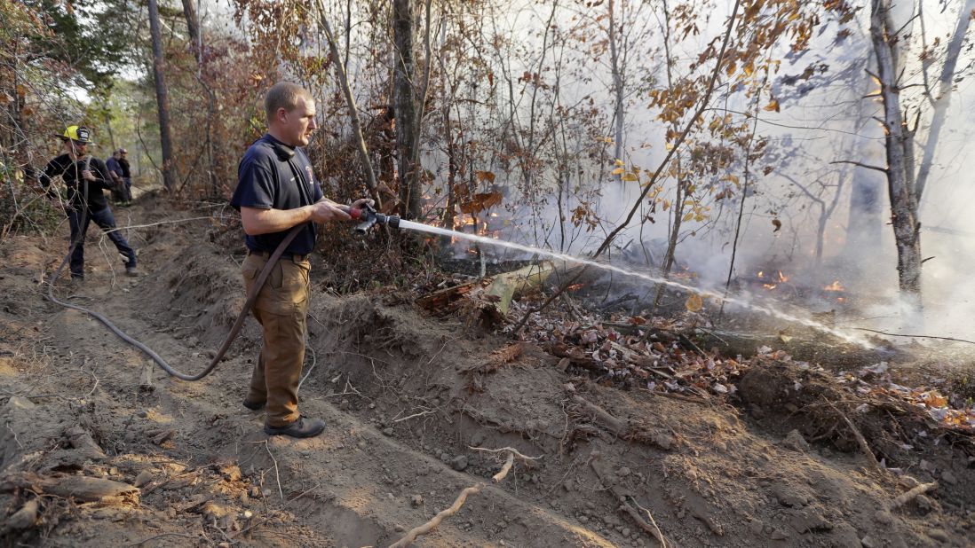 Assistant Fire Chief Brent Masey sprays water on a wildfire in Soddy-Daisy, Tennessee, on Thursday, November 10.