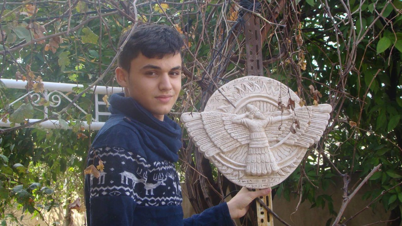 Thabit holds a picture of Ashur, a primary Assyrian deity and the god of war