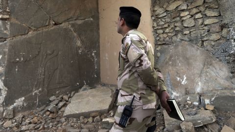 An Iraqi army officer looks at a damaged carved stone slab, destroyed by ISIS militants, in Nimrud.