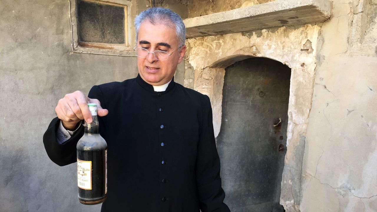 A bottle of wine is among the items Behnam Lalo was able to salvage from St. George Church in Bartella.
