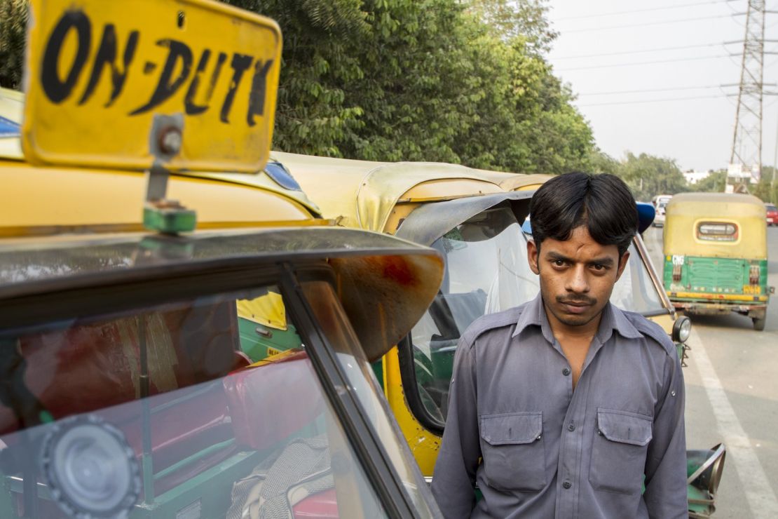 Sarvesh poses by his auto rickshaw.