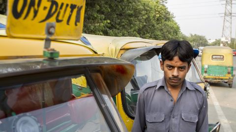 Sarvesh poses by his auto rickshaw.