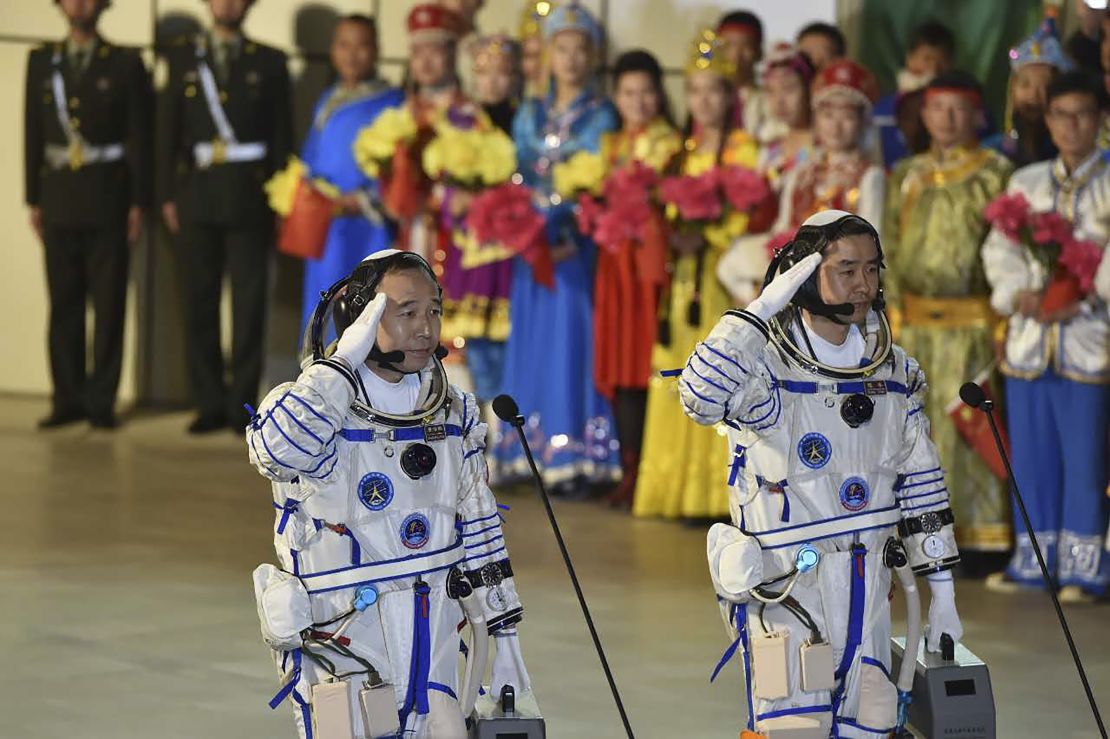Chinese astronauts Jing Haipeng (L) and Chen Dong salute during the send-off ceremony of the Shenzhou-11 manned space mission at the Jiuquan Satellite Launch Center in Jiuquan, China.