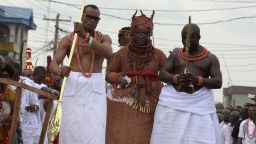 Newly crowned 40th Oba, or king, of the Benin kingdom, Oba Ewuare II , walks on a wooden bridge assisted by palace aides to perform the rite during his coronation. 

