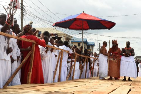 Newly crowned 40th Oba, or king, of the Benin kingdom, Oba Ewuare II , walks on a wooden bridge assisted by palace aides to perform the rite during his coronation. 
