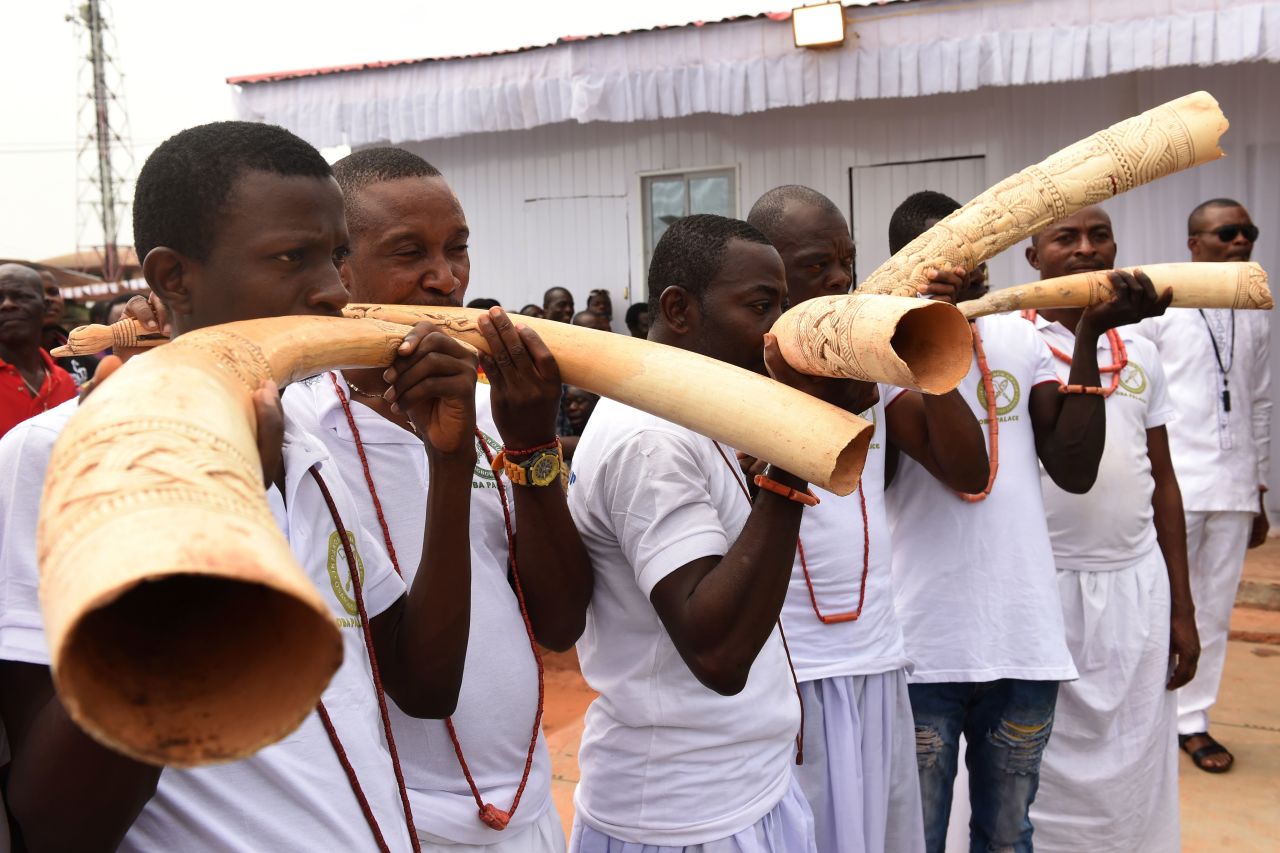 Royalist supporters blow in sculpt elephant tusks during the coronation ceremony.