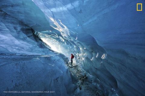Photo: Tom Schifanella, USA: "Since 2000, Icelandic glaciers have lost 12% of their size, in less than 15 years. Pictured here, Icelandic guide Hanna Pétursdóttir admires an ice cave inside the Svínafellsjökull Glacier, which she notes is rapidly expanding due to the effects of global warming," wrote Schifanella. <em>Via National Geographic Your Shot</em>