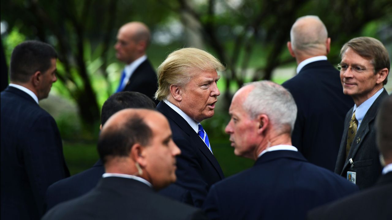 US Republican presidential nominee Donald Trump (C) is surrounded by members of the Secret Service as he visits the tomb of former US President Gerald Ford in Grand Rapids, Michigan, on September 30, 2016. 