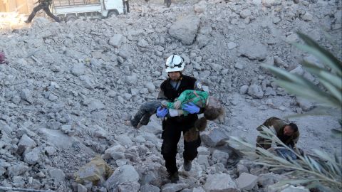 A man rescues a wounded child after an airstrike in Aleppo on November 18, 2016.