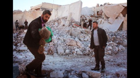 A wounded child is rescued by a White Helmets volunteer after airstrikes on eastern Aleppo Friday.