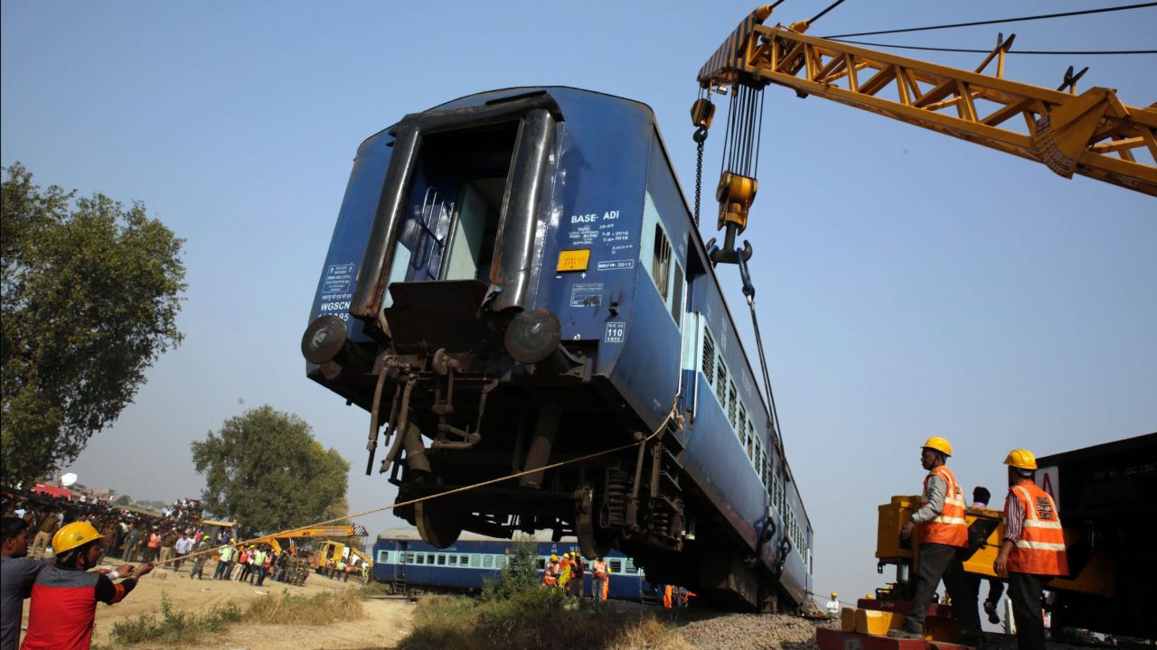 Rescuers lift one of the 14 coaches in the 23-car train that rolled off the track.