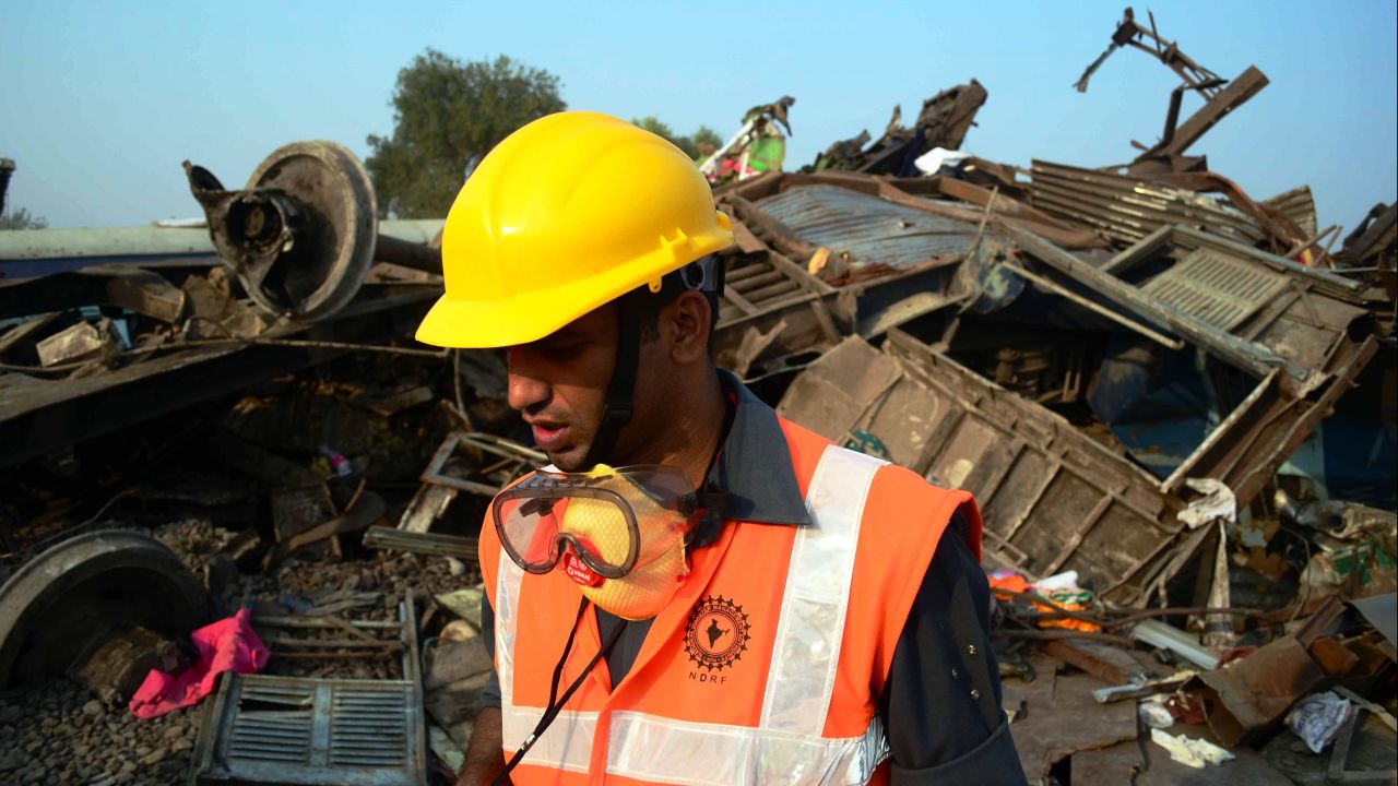 A National Disaster Response Force employee works at the derailment site in Pukhrayan.