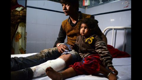 With her uncle at her side, a 2-year-old passenger of the derailed train gets admitted to a hospital in Pukhrayan.  