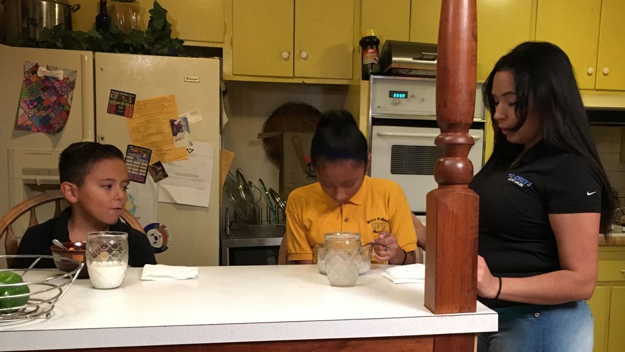 Lili's son Omar, 7, and her daughter Evelynne, 11, eat breakfast before Lili drops them off at school.