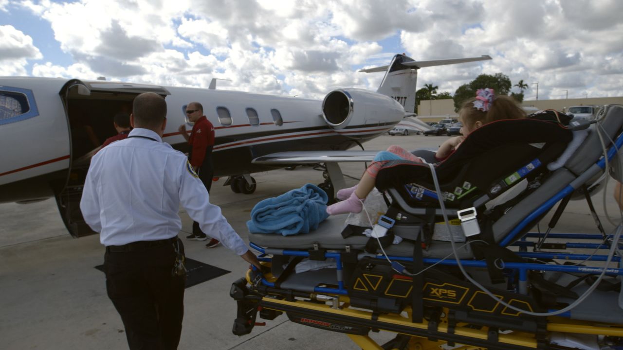 Paramedics transport Abby Muszynski to the air ambulance that will fly her from Florida to Colorado.