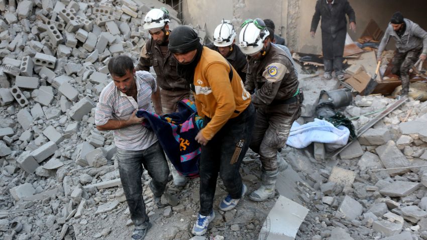 Syrian civil defence volunteers, known as the White Helmets, evacuate a victim from the rubble of a building following reported airstrikes on Aleppo's rebel-held district of al-Hamra on November 20, 2016. / AFP / THAER MOHAMMED (Photo credit should read THAER MOHAMMED/AFP/Getty Images)