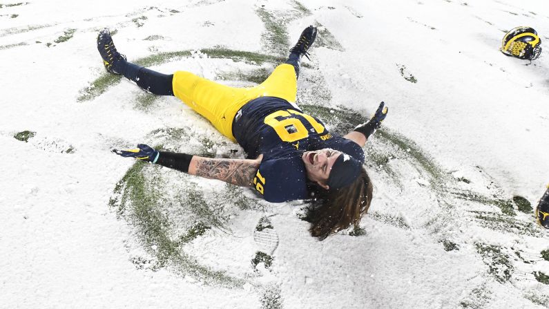 Michigan fullback Henry Poggi makes a snow angel after a 20-10 home win over Indiana on Saturday, November 19.