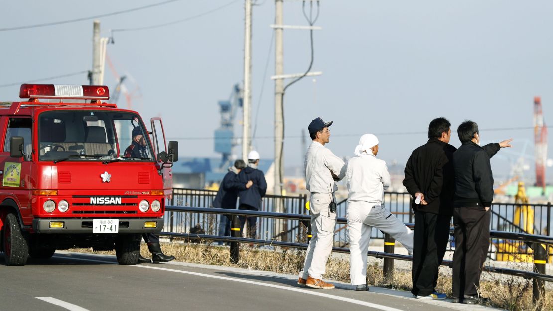 Firefighters watch the port to check the water level after a tsunami warning in Soma, Fukushima prefecture, Tuesday, November 22.