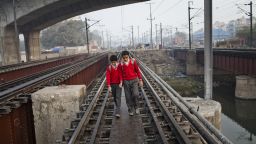 Boys walk to school over railway tracks close to the Nizamuddin Railway Station in New Delhi, India. 