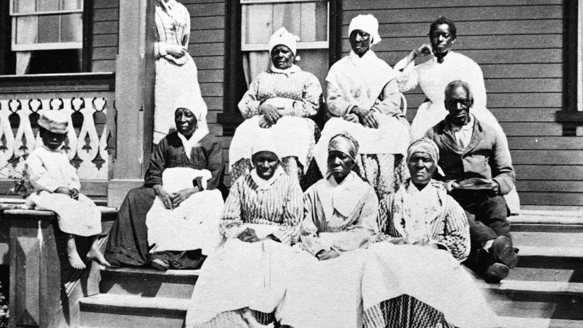 A group of women and a man, presumably slaves, sit on the steps of the Florida Club, St. Augustine, Florida, mid 19th Century. A white woman, possibly a manager or overseer, stands behind them to the left and a child sits on the newel post. (Photo by Hulton Archive/Getty Images)