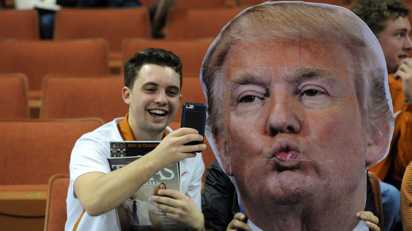 A basketball fan at the University of Texas takes a selfie with a Donald Trump cutout before a game on Tuesday, January 12. Celebrity heads have become a popular feature at many basketball games, with fans waving them to distract opposing free-throw shooters.