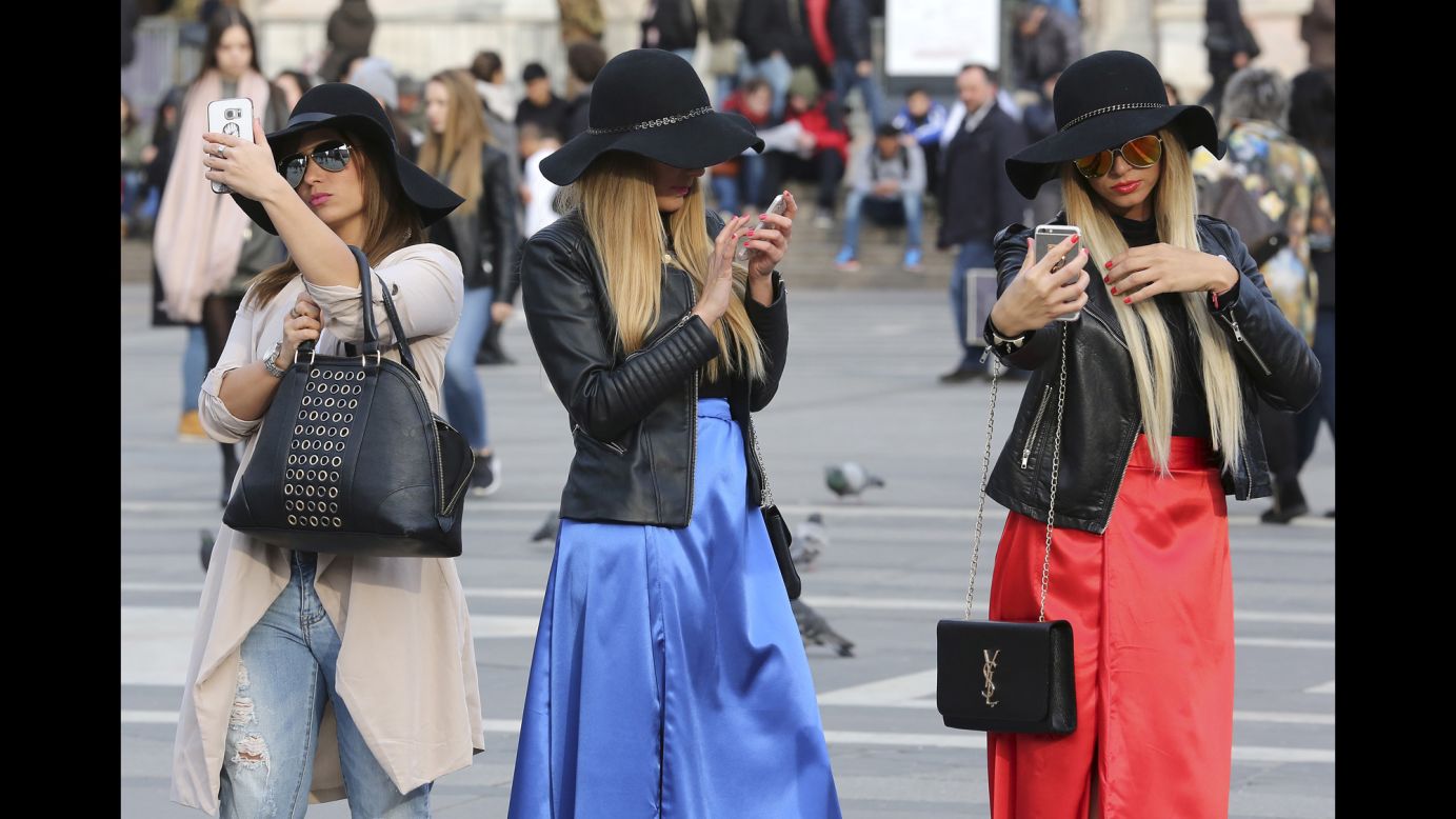 Women use their cell phones in Milan, Italy, on Thursday, February 25.