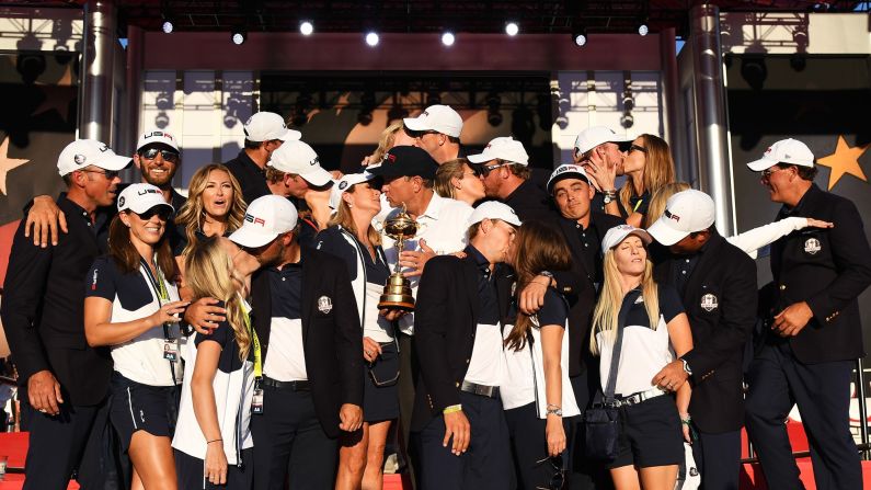 Golfer Rickie Fowler shrugs as his US teammates kiss their wives and girlfriends <a href="index.php?page=&url=http%3A%2F%2Fwww.cnn.com%2F2016%2F10%2F03%2Fgolf%2Fryder-cup-2016-reactions-obama-arnold-palmer%2Findex.html" target="_blank">during a team photo</a> on Sunday, October 2. The Americans had just won <a href="index.php?page=&url=http%3A%2F%2Fwww.cnn.com%2F2016%2F10%2F02%2Fgolf%2Fgolf-ryder-cup-usa-europe%2Findex.html" target="_blank">their first Ryder Cup since 2008.</a>