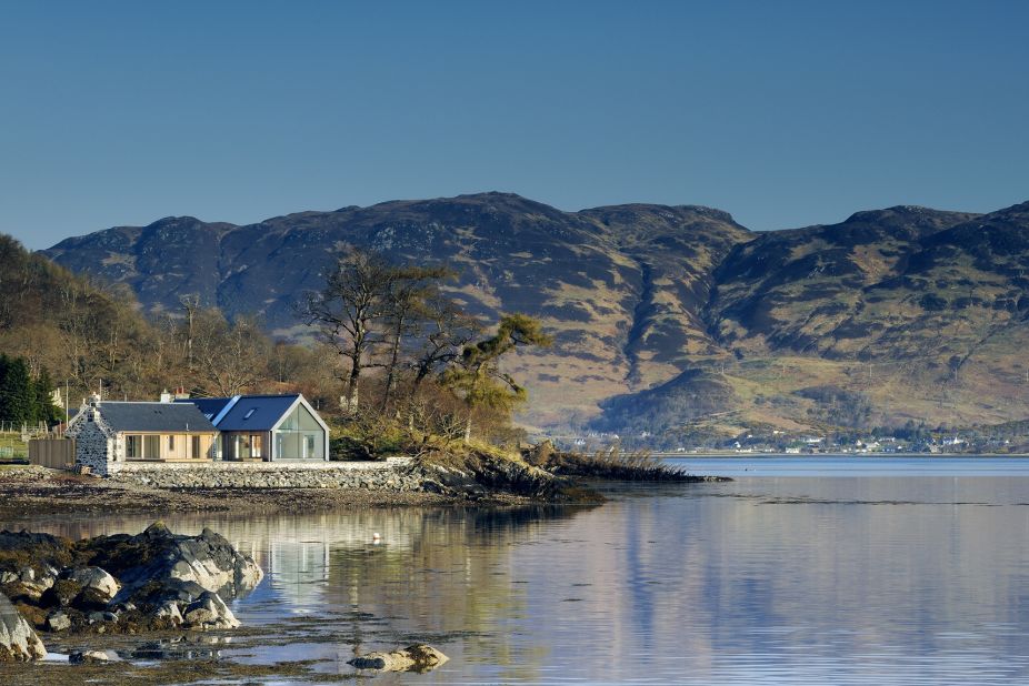This Rural Design/R.HOUSE collaboration is situated on the edge of Loch Duich, featuring a stunning view of the famous Eilean Donan Castle.