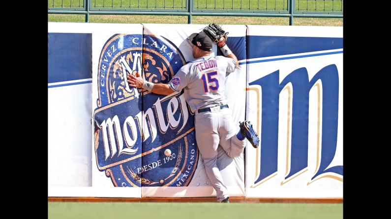 Tim Tebow crashes into the outfield wall as he tries to catch a fly ball during a minor-league baseball game in Glendale, Arizona, on Tuesday, October 11. The former Heisman Trophy winner, who last played in the NFL in 2012, <a href="index.php?page=&url=http%3A%2F%2Fwww.cnn.com%2F2015%2F05%2F08%2Fopinions%2Fcoy-wire-tim-tebow-chases-dream%2F" target="_blank">is now giving pro baseball a shot.</a>