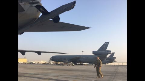 A crew member walks toward a KC 10 back on the tarmac.