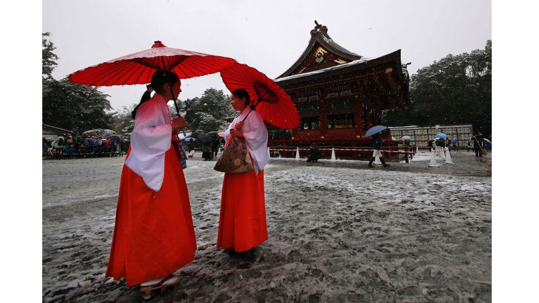 Shrine maidens chat in the snow at the Tsurugaoka Hachimangu Shrine, near Tokyo.  The weather was a challenge for people choosing to wear the traditional kimono.