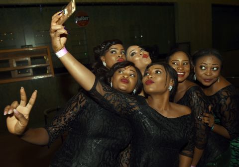 The spectacular growth in mobile demand should result in 730 million individual subscribers by 2020. It's market is second only to that of the Asia-Pacific region.<br /><br />Pictured: Hostesses take a selfie during the African Footballer of the Year Award in Abuja, Nigeria on January 7, 2016.