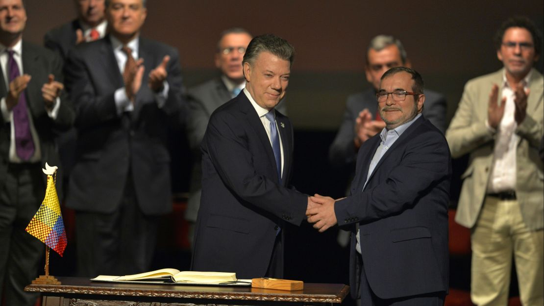 Santos, left, and FARC leader Timoleon Jimenez seal the revised deal.