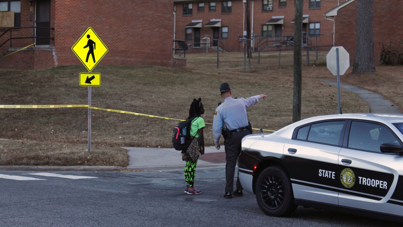 A child gets guidance from a North Carolina state trooper after <a href="http://www.newsobserver.com/news/local/crime/article116421508.html" target="_blank" target="_blank">police fatally shot a man</a> at a Durham housing project on Tuesday, November 22.