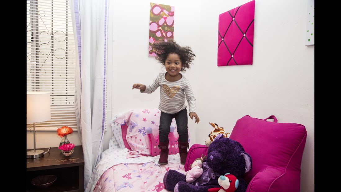 Ja'el jumps on a pink bed in her new apartment in Los Angeles. Art is an important component to making a house a home, Smith said.