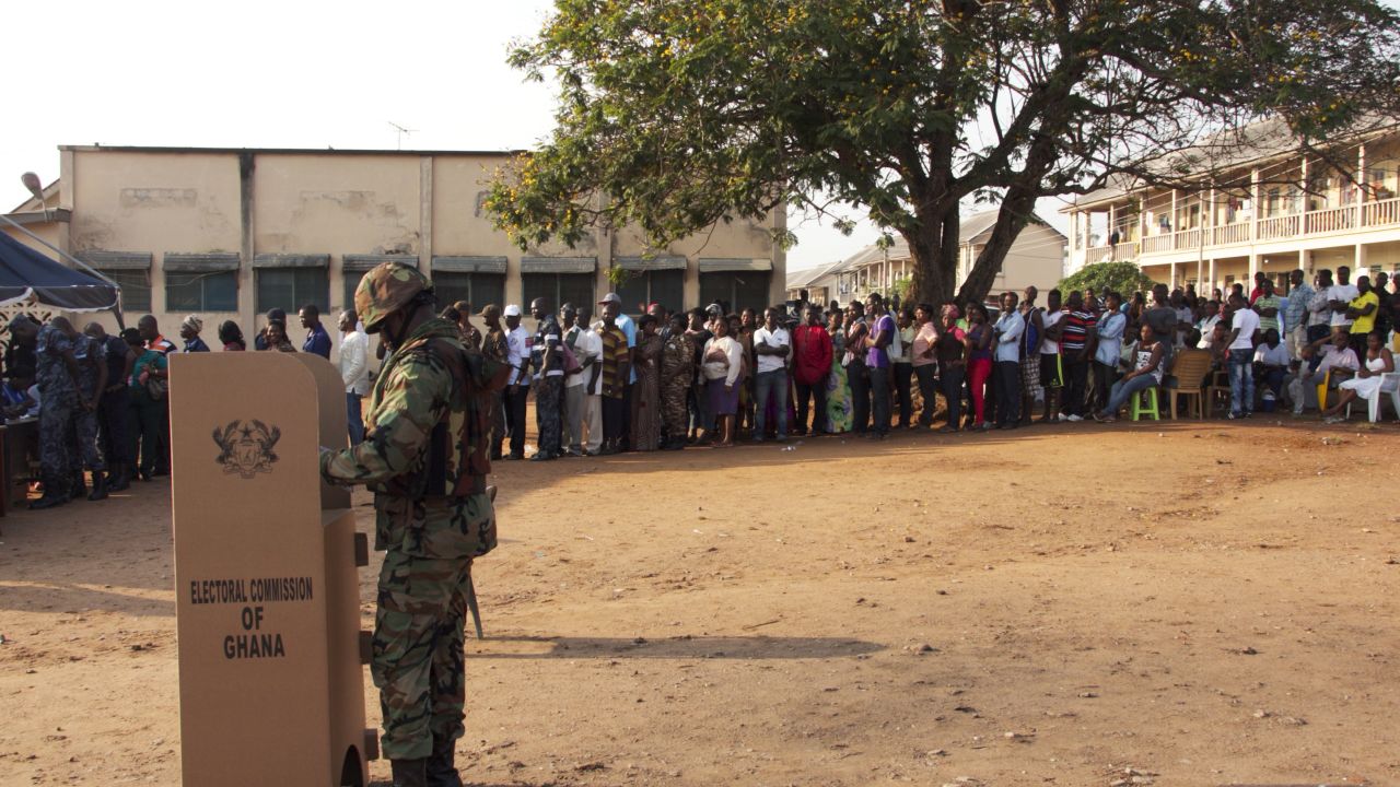 A soldier casts his ballot at a polling station as other voters wait in line, in Accra, on December 7, 2012.