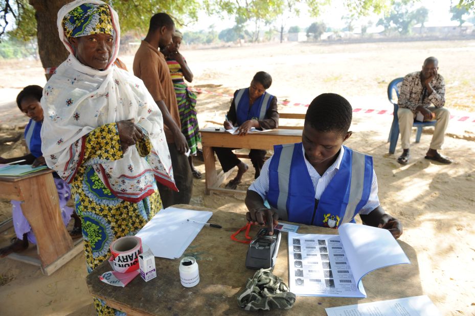 Eight in 10 Ghanaians believe the presence of armed security personnel at polling stations during the 2016 polls will make them feel more secure.<br /> <br />Pictured: An electoral officer checks the identity of a voter at the Bole polling station, in December 2012. Photo Pius Utomi Ekpei/AFP/Getty Images.