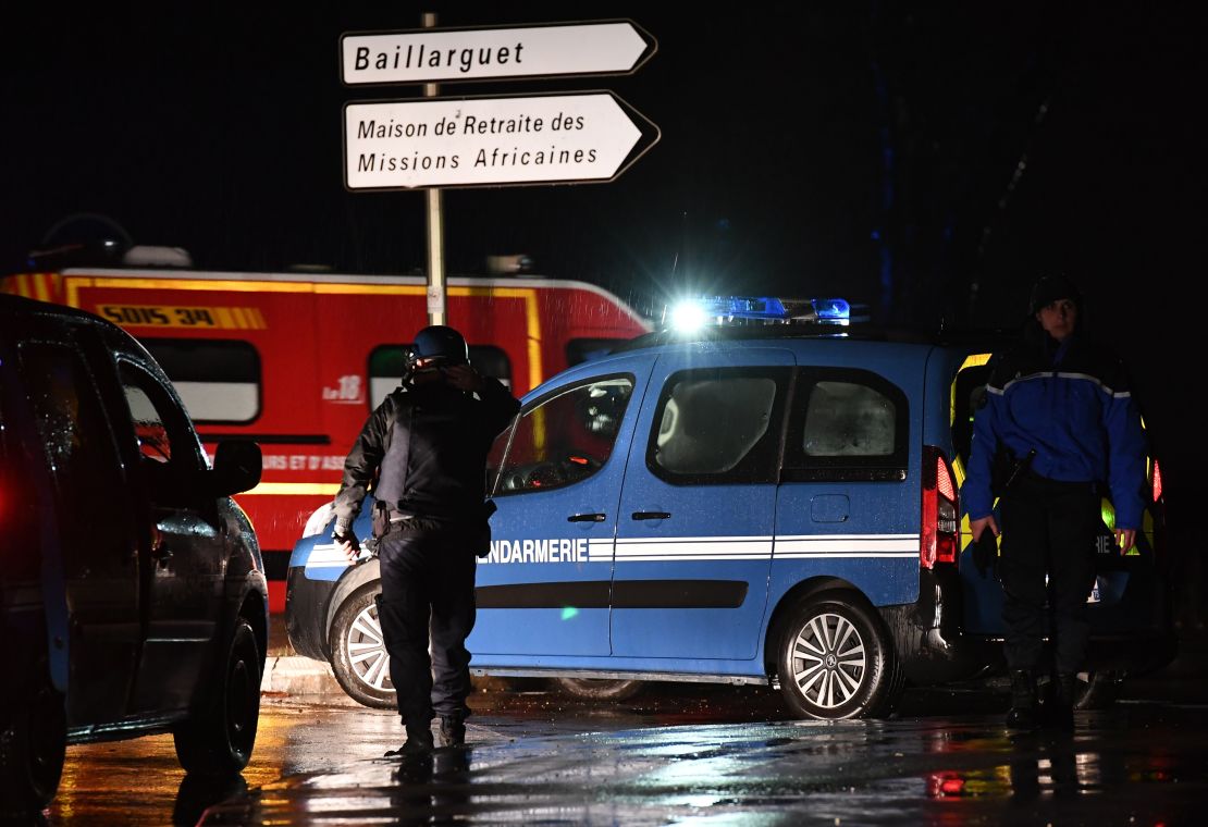 Gendarmes stand guard on a road near a retirement home for priests in Montferrier-sur-Lez.