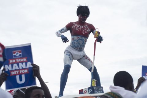 An NPP supporter dances on a car at the party manifesto launch in Accra in October 2016.<em> </em>