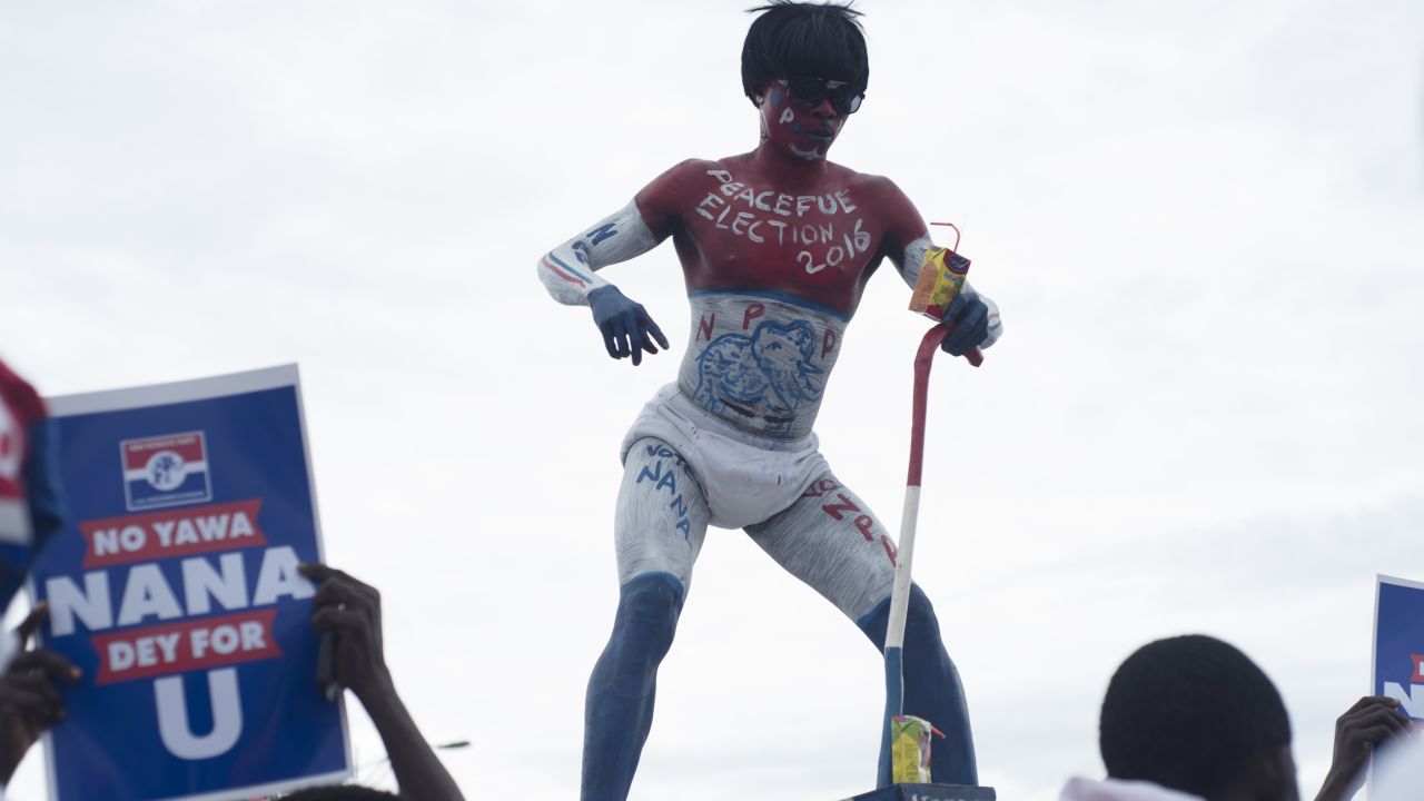 A supporter of Ghana's largest opposition party New Patriotic Party (NPP) dances ontop of a car at the party manifesto launch in Accra on October 9, 2016.
