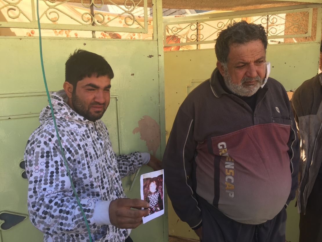 Distraught father Omar Ali holds a picture of his daughter Amira who was killed by an ISIS mortar. 