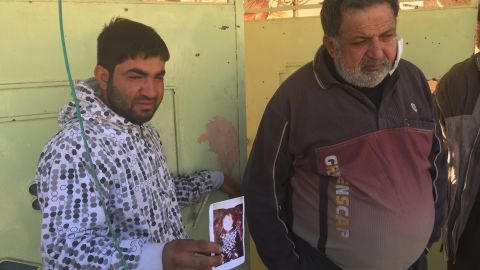 Distraught father Omar Ali holds a picture of his daughter Amira who was killed by an ISIS mortar.