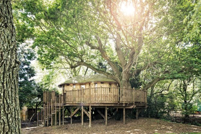 "Little Acorn Treehouse" is nestled among the boughs of an enormous oak tree. The tree house was designed in natural tones to mimic the earth, tree trunk and leaves of the host tree.