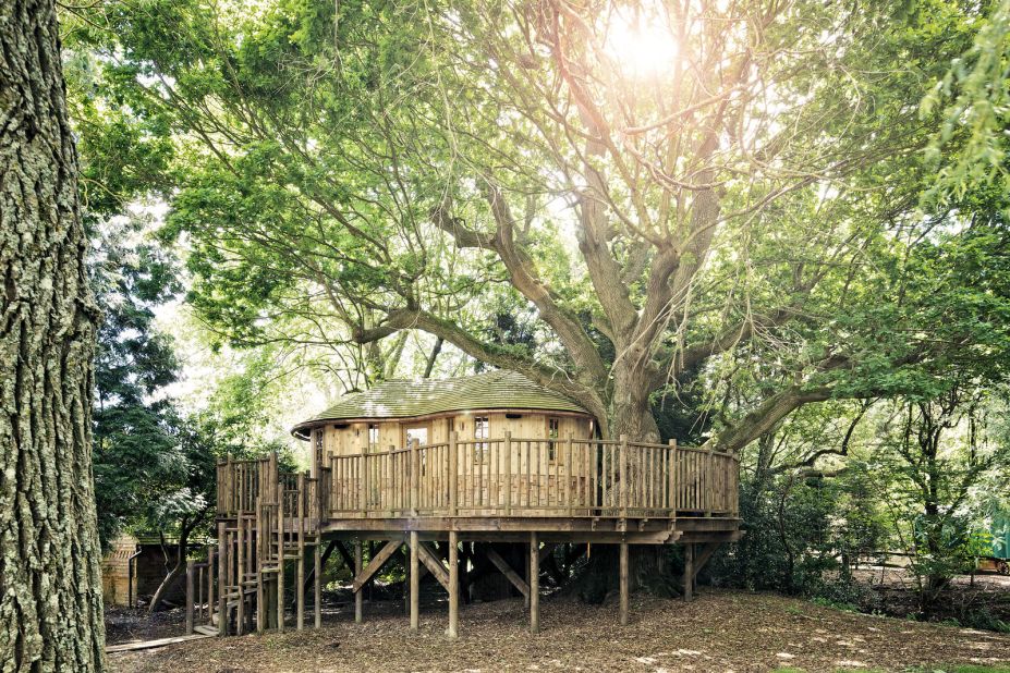 "Little Acorn Treehouse" is nestled among the boughs of an enormous oak tree. The tree house was designed in natural tones to mimic the earth, tree trunk and leaves of the host tree.