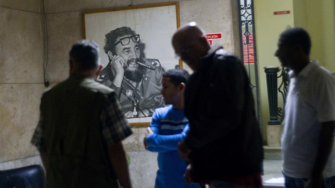People gather at an office of the Popular Assembly in Havana in front of a picture of the iconic leader on November 26 after President Raul Castro announced his brother's death on television.