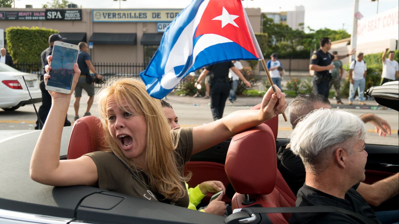 People take to the streets to react to the news of the death of former Cuban President Fidel Castro outside the restaurant Versailles in Miami.