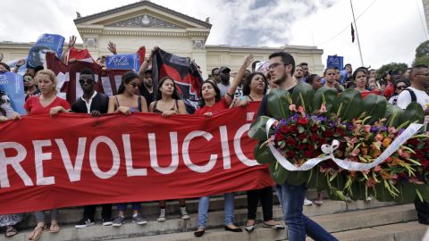 Cuban students chant slogans and carry a wreath as they mourn the death of revolution leader Fidel Castro, at the University of Havana, on November 26, 2016, in Havana. 