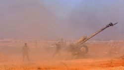 Syrian pro-government fighters fire a Russian 122mm howitzer gun as they advance in the recently recaptured village of Joubah during an offensive towards the area of Al-Bab in Aleppo province, on November 25, 2016. The Syrian army advanced in Aleppo, pounding the rebel-held east with strikes that killed dozens and added to the despair for more than 250,000 civilians under siege.