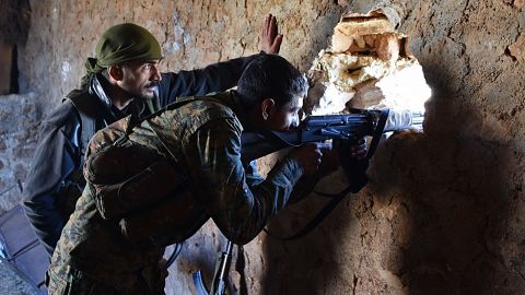 A pro-government soldier mans a damaged house in the recently recaptured village of Joubah in Aleppo province on Friday.